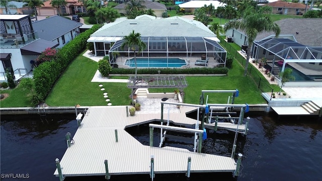 view of dock with a water view and a lawn