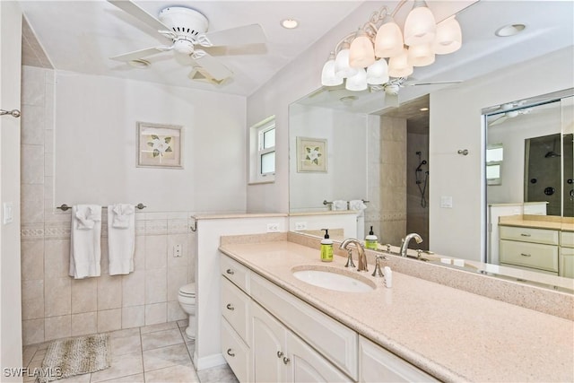 bathroom with vanity, tile patterned floors, toilet, tile walls, and walk in shower