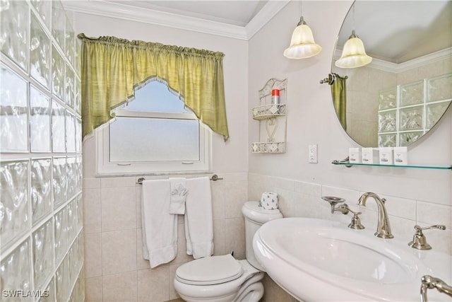 bathroom with sink, ornamental molding, tile walls, and toilet