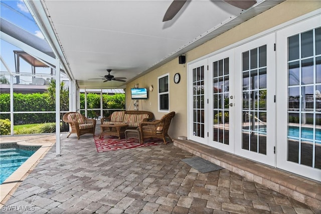 view of patio featuring ceiling fan, an outdoor living space, glass enclosure, and french doors