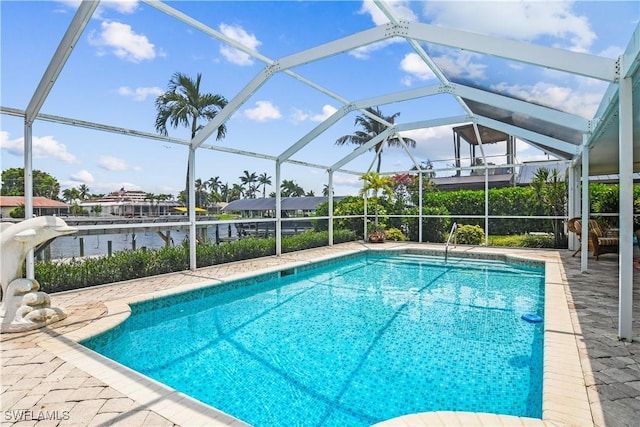 view of swimming pool with a lanai, a water view, and a patio