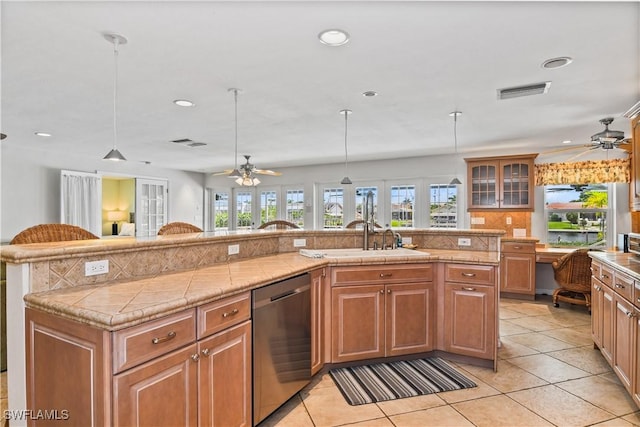 kitchen with dishwasher, pendant lighting, french doors, and a kitchen island with sink