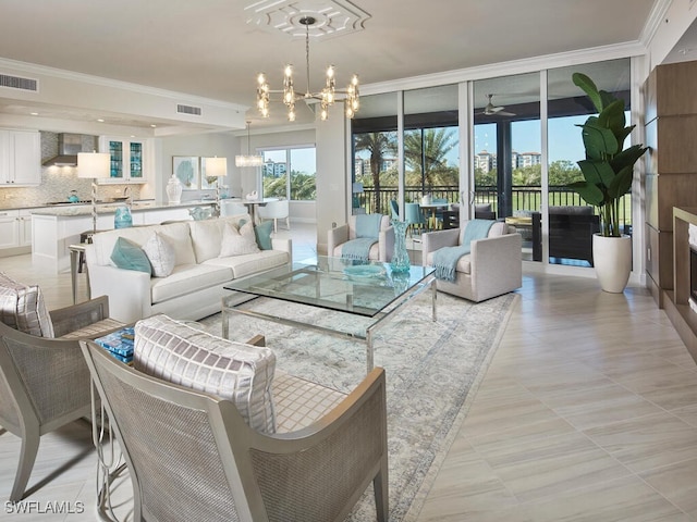 living room featuring light tile patterned floors, ceiling fan with notable chandelier, and ornamental molding