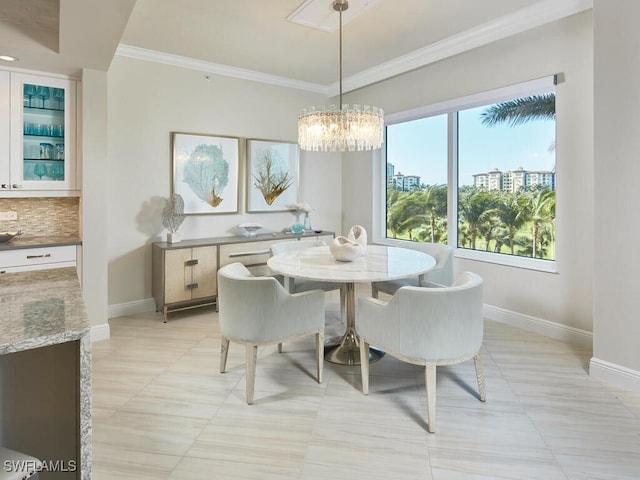 dining space with light tile patterned floors, ornamental molding, and an inviting chandelier