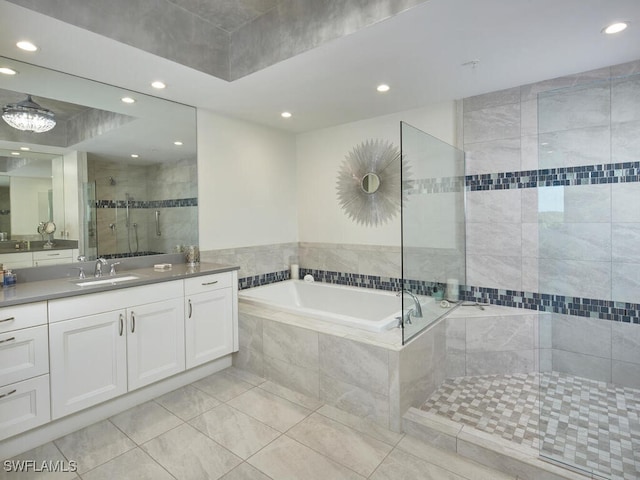 bathroom with tile patterned floors, vanity, and shower with separate bathtub