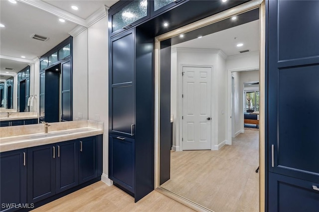 bathroom featuring hardwood / wood-style floors, vanity, and crown molding