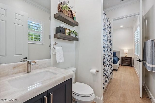 bathroom featuring crown molding, vanity, wood-type flooring, and toilet