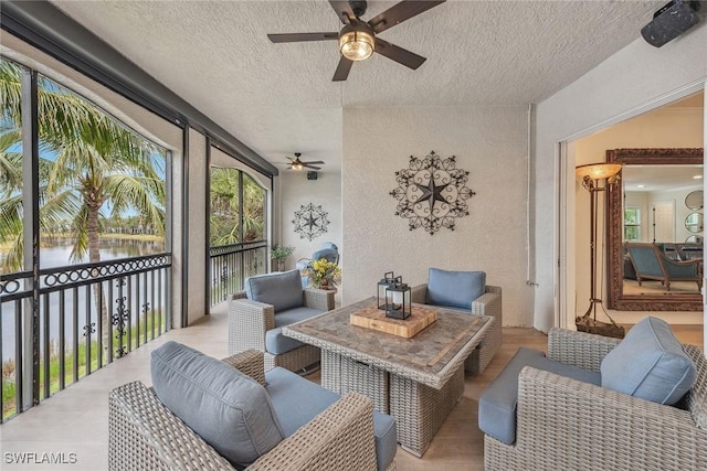 sunroom / solarium featuring a water view and ceiling fan