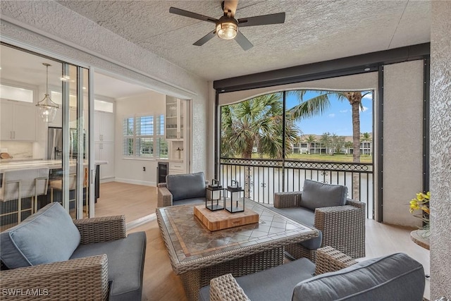 sunroom / solarium with beverage cooler and ceiling fan with notable chandelier