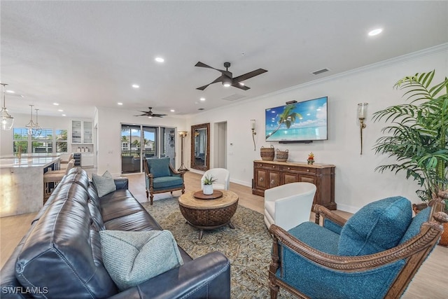 living room with ceiling fan, crown molding, and light wood-type flooring