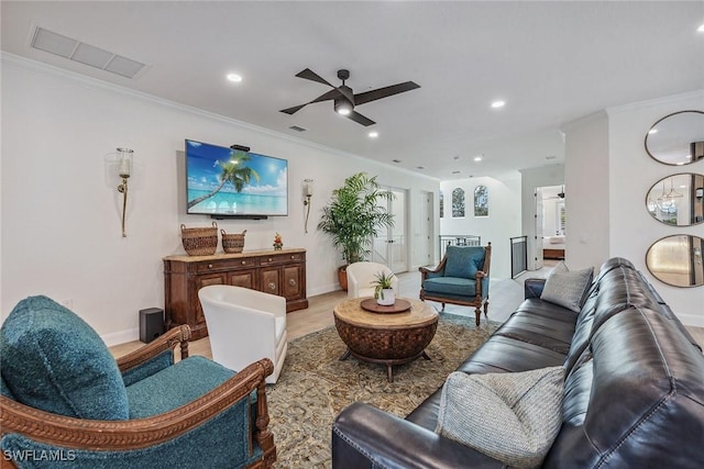 living room featuring ceiling fan, light wood-type flooring, and ornamental molding