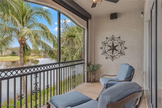 balcony featuring ceiling fan and a water view