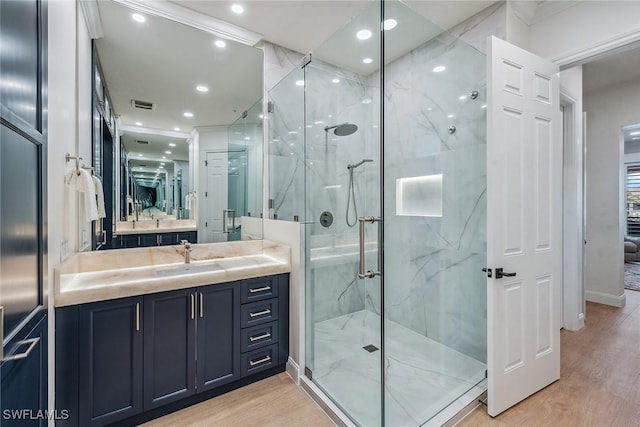 bathroom featuring hardwood / wood-style floors, vanity, and a shower with door