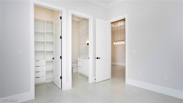 unfurnished bedroom featuring connected bathroom and a spacious closet