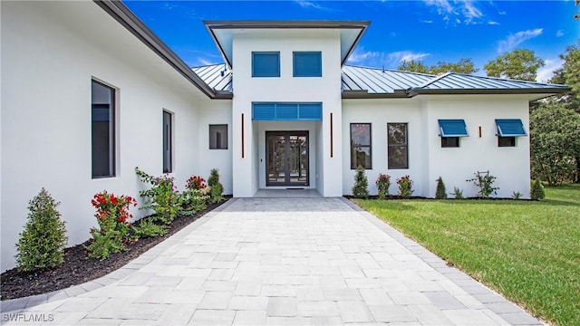 property entrance with a lawn and french doors