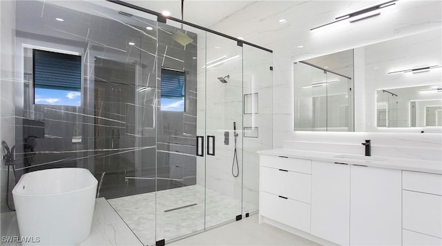 bathroom with vanity and shower with separate bathtub