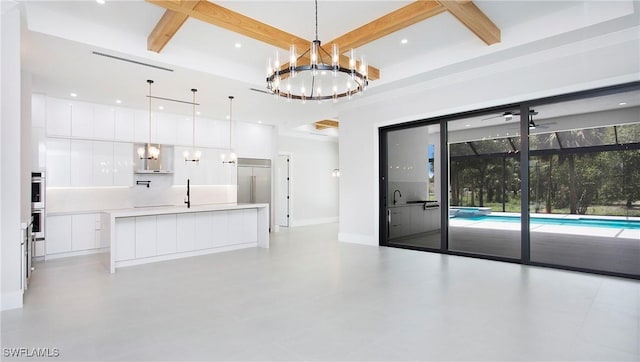 kitchen with coffered ceiling, white cabinetry, beamed ceiling, and hanging light fixtures