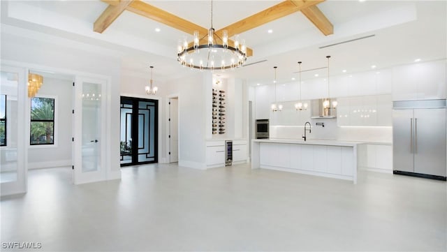 living room with coffered ceiling, a chandelier, and beam ceiling