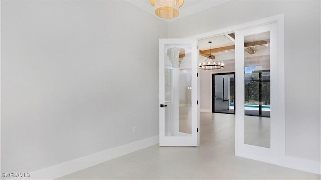 spare room featuring french doors and a chandelier