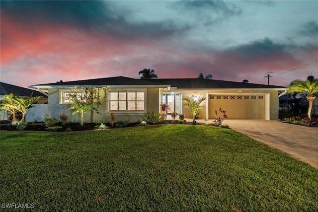 ranch-style house featuring a lawn and a garage