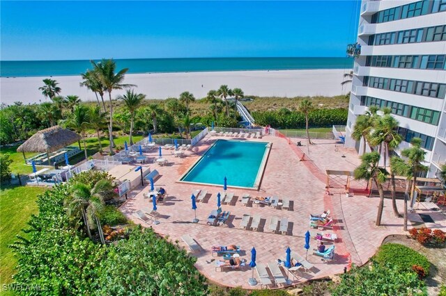 view of swimming pool featuring a water view and a view of the beach