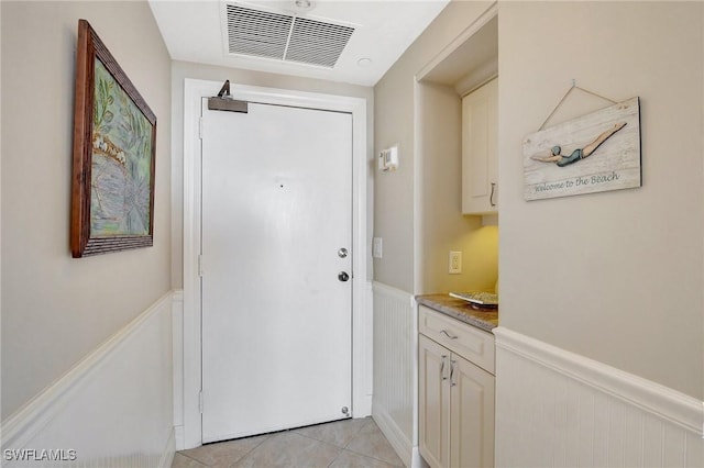 doorway to outside with light tile patterned floors