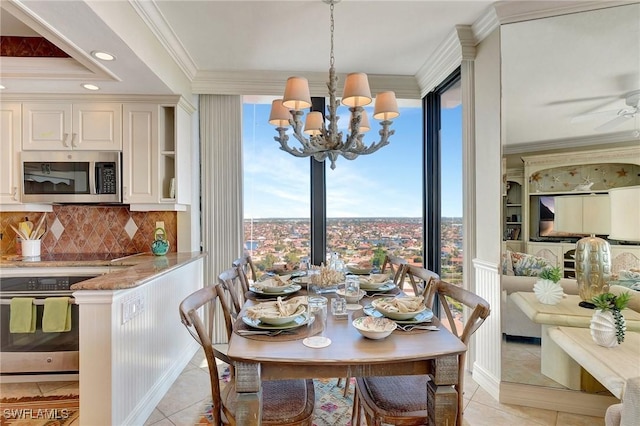 tiled dining space with ceiling fan with notable chandelier, a wealth of natural light, and crown molding