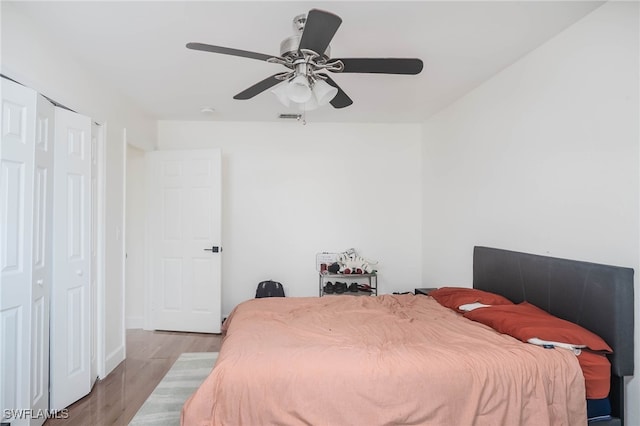 bedroom featuring light wood-type flooring, a closet, and ceiling fan