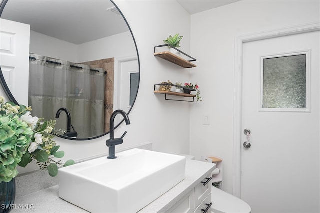 bathroom with vanity, curtained shower, and toilet