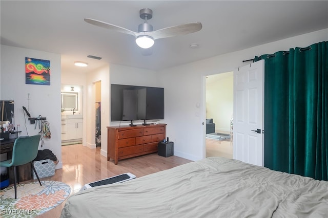 bedroom featuring ensuite bath, ceiling fan, and light hardwood / wood-style flooring