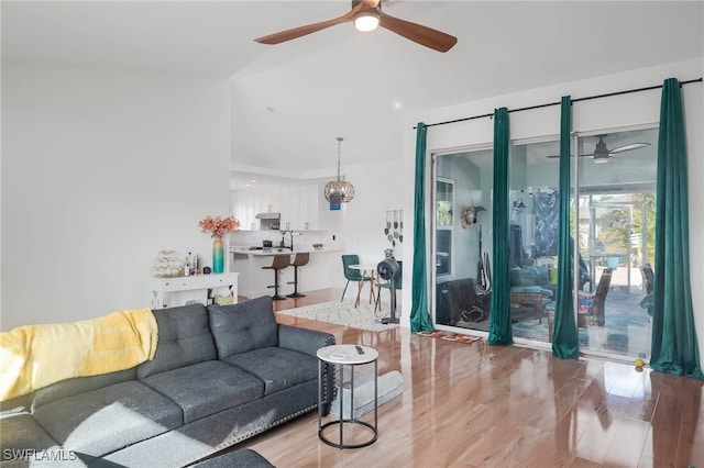 living room featuring light hardwood / wood-style floors, lofted ceiling, and sink