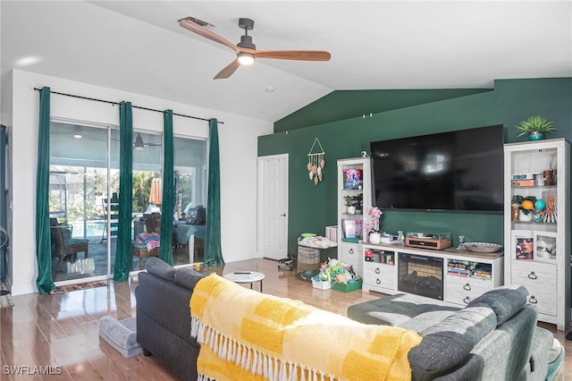 living room featuring ceiling fan, wood-type flooring, and lofted ceiling