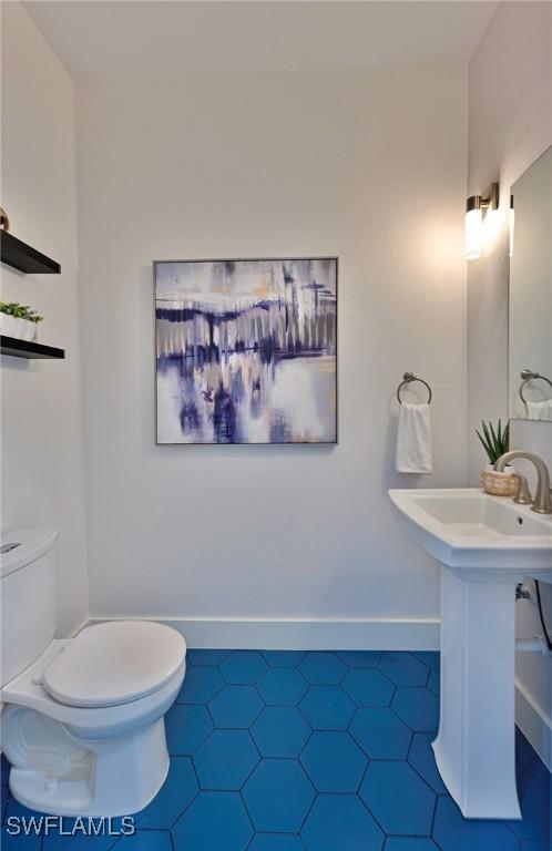 bathroom featuring toilet, tile patterned floors, and sink