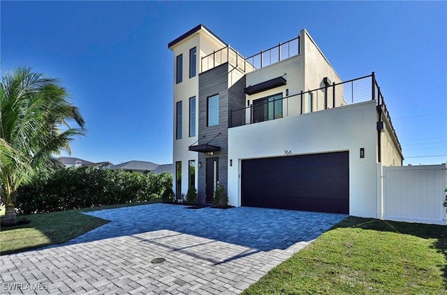 view of front of house with a balcony, a front yard, and a garage