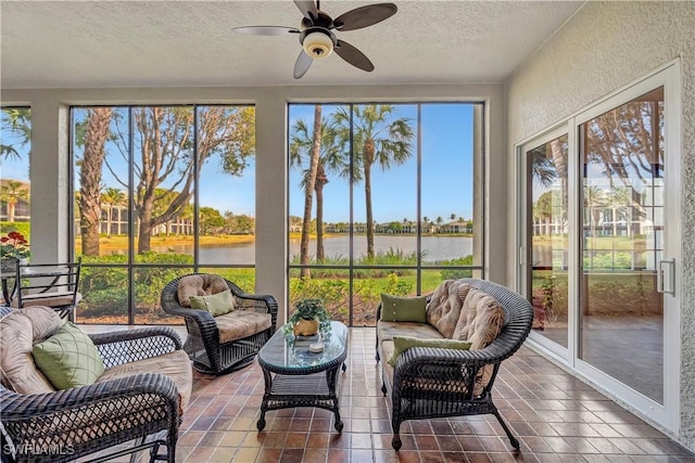 sunroom featuring a water view and ceiling fan