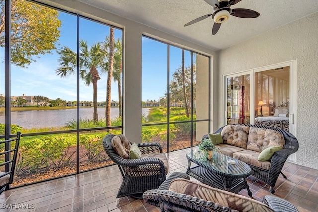 sunroom / solarium featuring a wealth of natural light, ceiling fan, and a water view