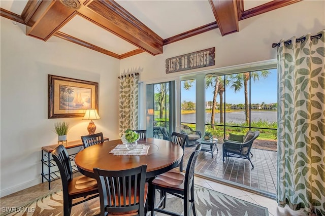 tiled dining space with beamed ceiling and a water view