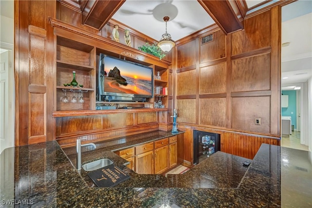 home office with beamed ceiling, beverage cooler, sink, and wooden walls