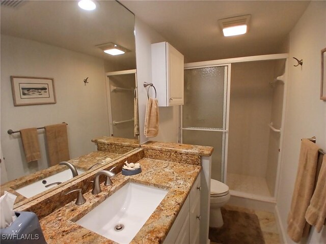 bathroom with toilet, walk in shower, and vanity