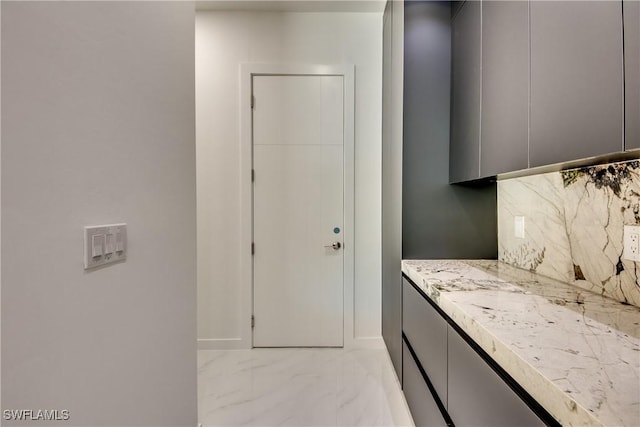 interior space featuring tasteful backsplash and gray cabinetry