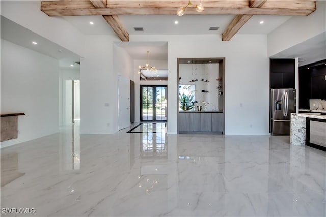 foyer featuring beamed ceiling, french doors, and a notable chandelier