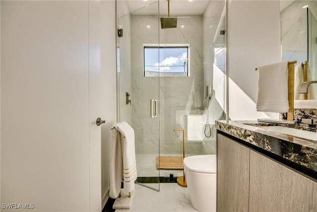 bathroom featuring vanity, a shower with door, and toilet