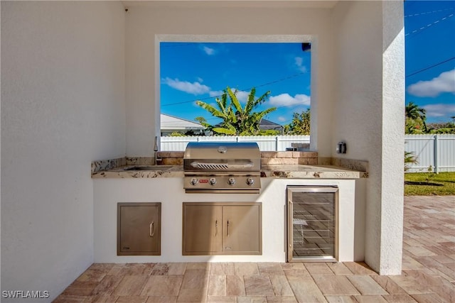 view of patio / terrace featuring a grill, beverage cooler, sink, and exterior kitchen