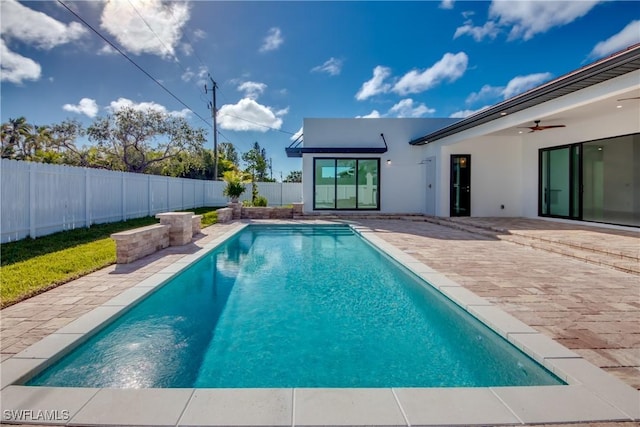 view of swimming pool featuring ceiling fan and a patio