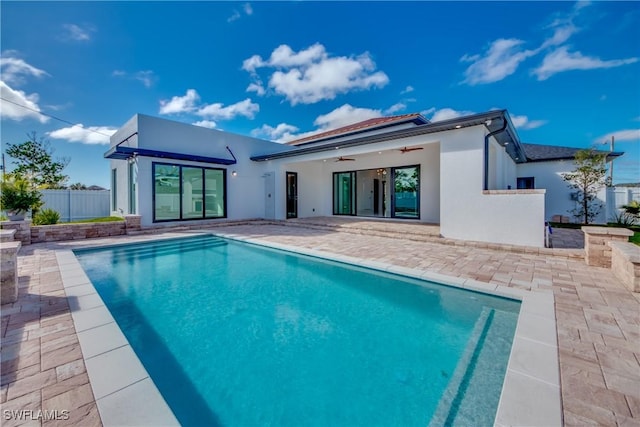 rear view of house featuring a fenced in pool, a patio, and ceiling fan