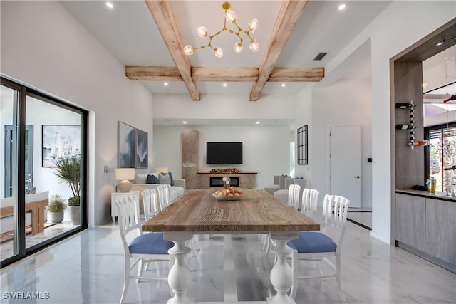 dining space featuring beam ceiling, a high ceiling, and a notable chandelier