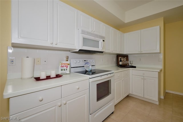 kitchen with white cabinets, light tile patterned flooring, white appliances, and tasteful backsplash