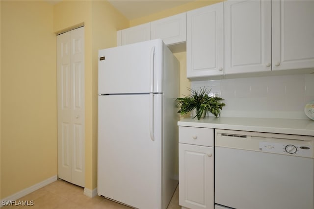 kitchen with white cabinetry, white appliances, light tile patterned floors, and tasteful backsplash