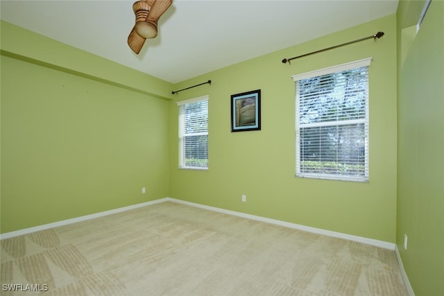 carpeted spare room featuring ceiling fan