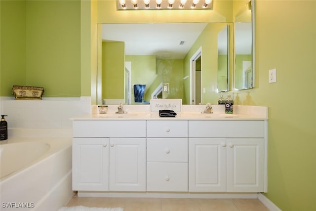 bathroom with a tub, tile patterned flooring, and vanity